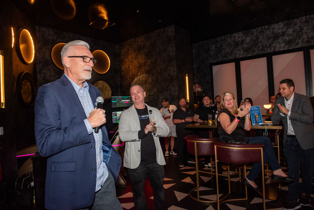 Speaker addressing the crowd at a Data Driverz event while the team applauds